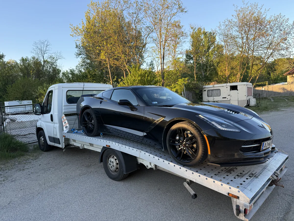 Fekete Chevrolet Corvette sportautó szállítása Gyors Autómentés platós autómentőn